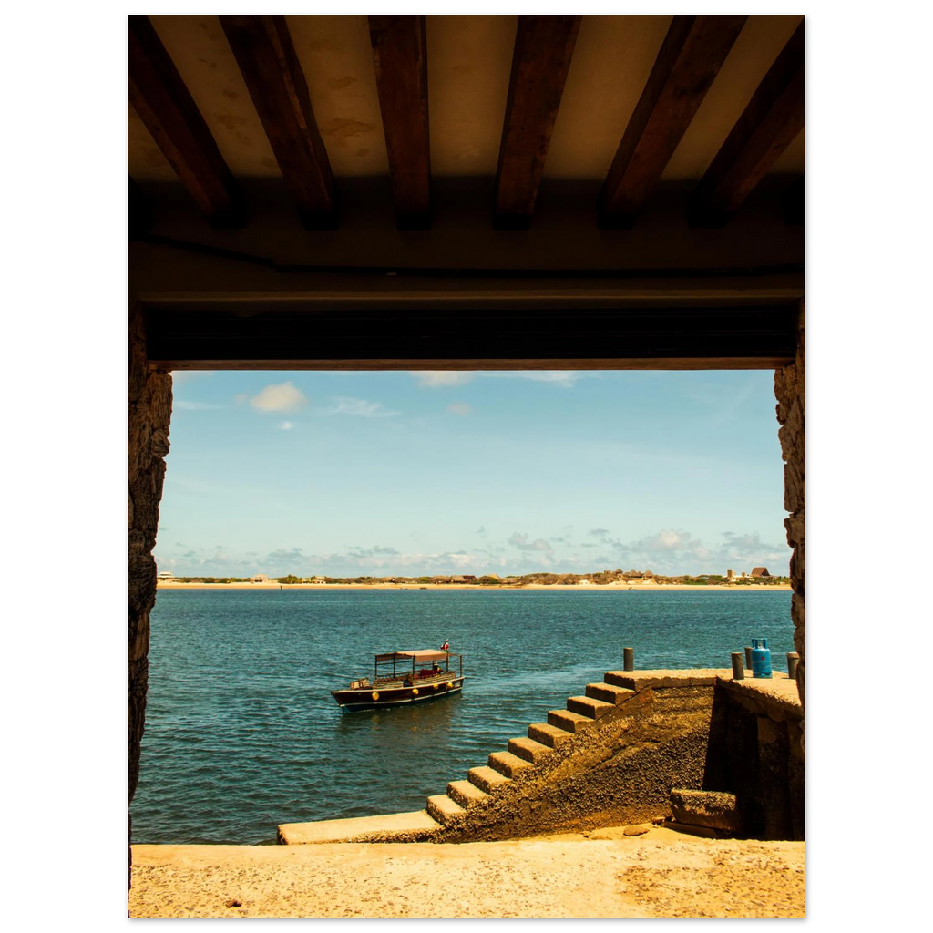 View of a dock with a boat on a body of water, framed by wooden beams.
