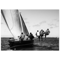 Black and white photo of a group of men on a wooden sailing boat.