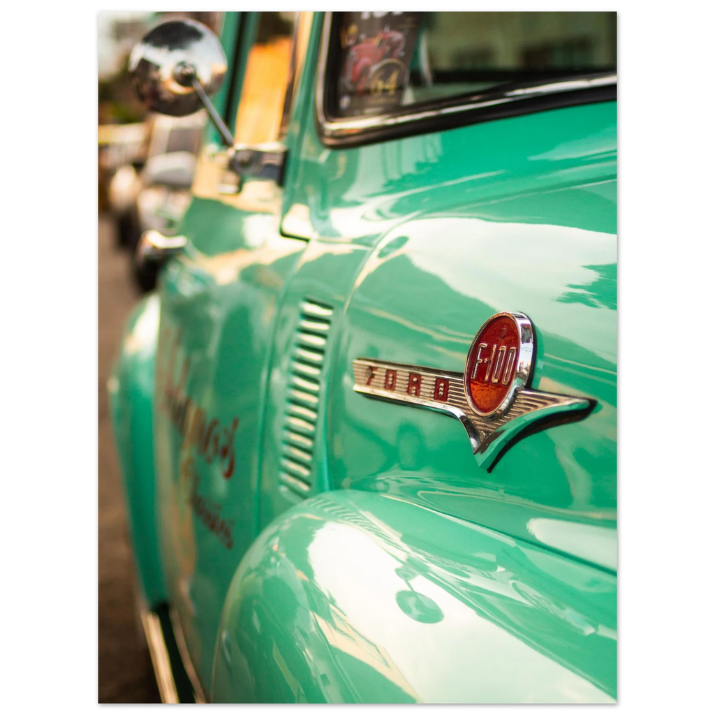 Close-up of a vintage green Ford truck with the logo visible.