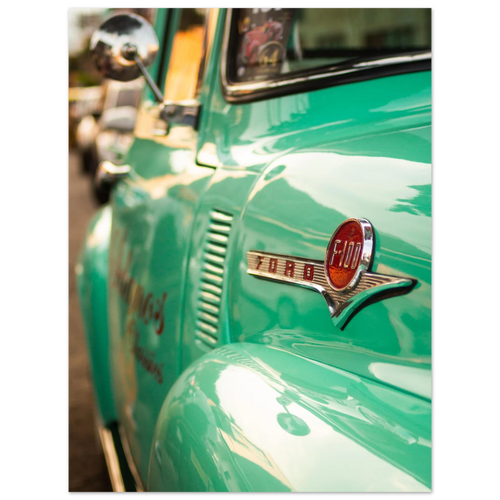Close-up of a vintage green Ford truck with the logo visible.